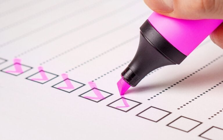 Checklist avec stylo rose en surbrillance, organisation, planification et productivité.