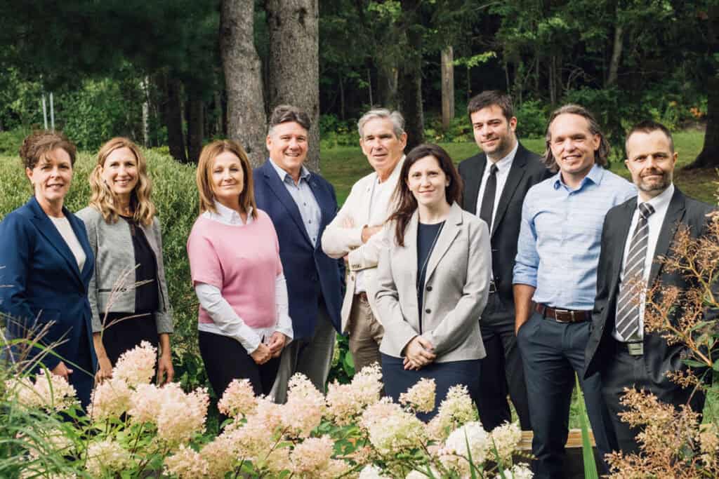 Famille d'affaires élégante en extérieur, souriante, look professionnel, arbre et végétation, ambiance chaleureuse, succès et travail d'équipe.