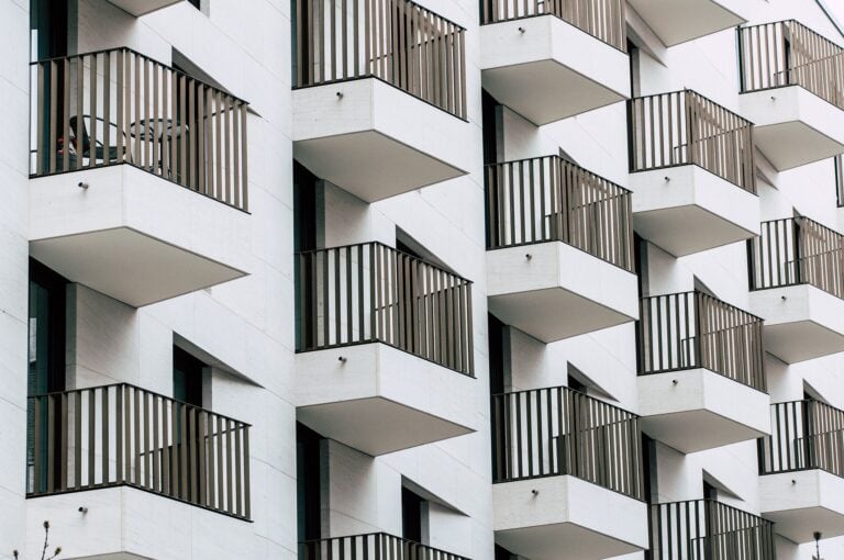 Modern building balcony with wood railing, contemporary architecture, urban-style residential buildings, minimalist design, city housing in Montreal.